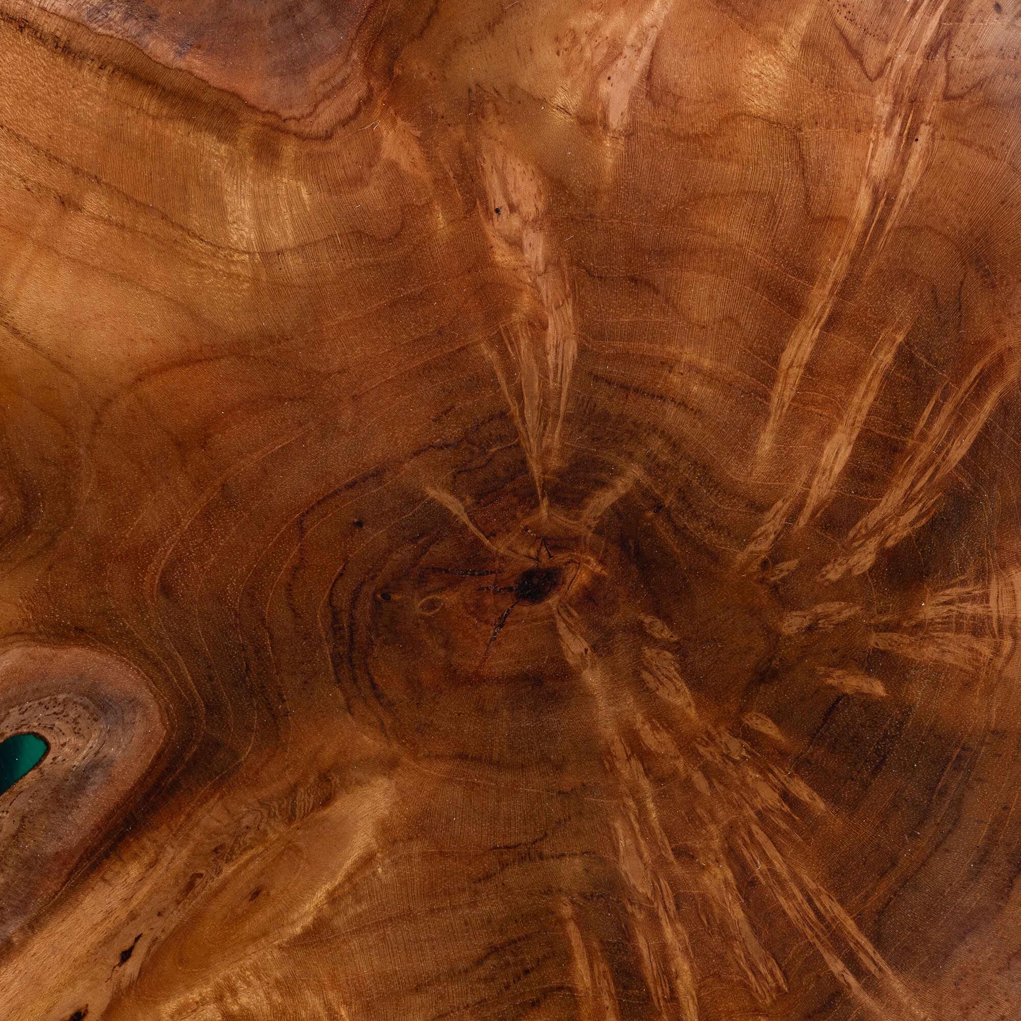 Teak wood grain and teal epoxy resin close-up on round end table