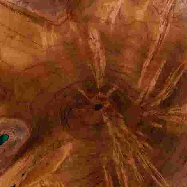Teak wood grain and teal epoxy resin close-up on round end table