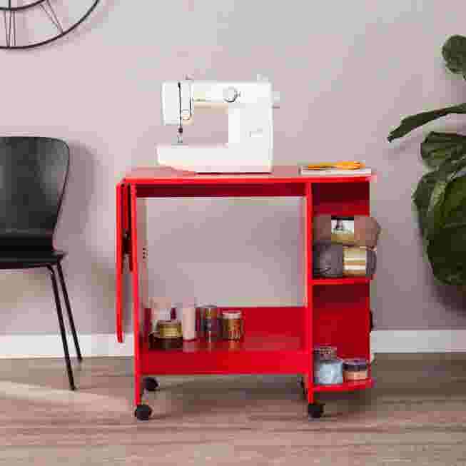 red sewing table with sewing machine and supplies