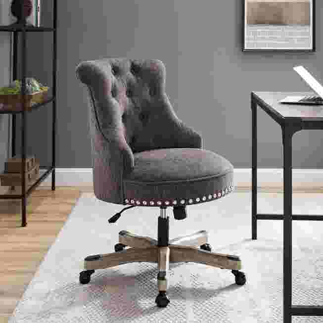 Grey tufted office chair in a home desk setup