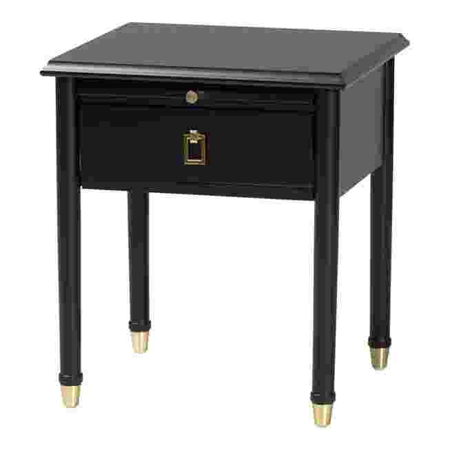 Close-up of black nightstand with metal pulls and gold feet